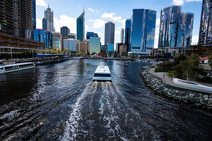 A passenger ferry boat arrives from a Swan River cruise to dock in the Perth harbour of Queen Elizabeth Quay, Western Australia  