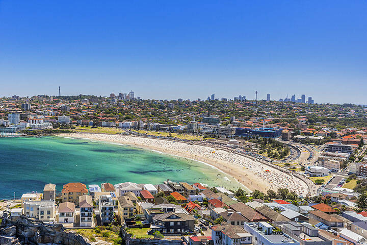 Aerial view of busy Bondi Beach on a blue sky day, 
