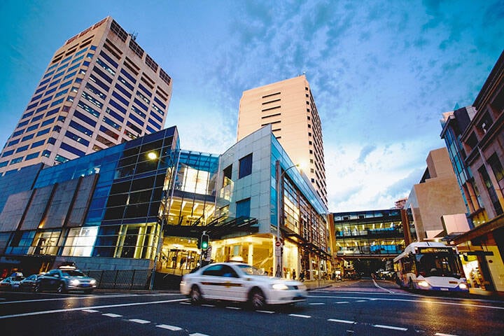 Cars and buses driving through Bondi Junction interchange at sunset in Sydney