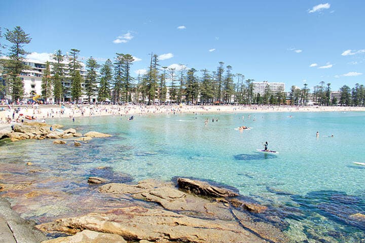 Stand-up paddleboarders, swimmers and beachgoers at Shelly Beach and Manly Beach, Sydney, New South Wales, Australia