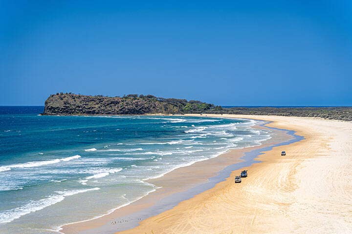 Scenic views looking towards Indian Head, with 4x4 vehicles driving on K'Gari, Fraser Island, Queensland, Australia. 