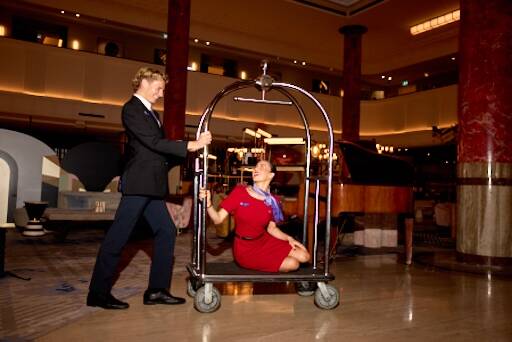Two flight attendants pushing a luggage cart