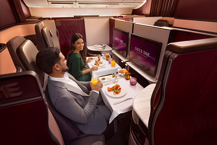Couple enjoying a meal in the Qsuite in Qatar's business class cabin.