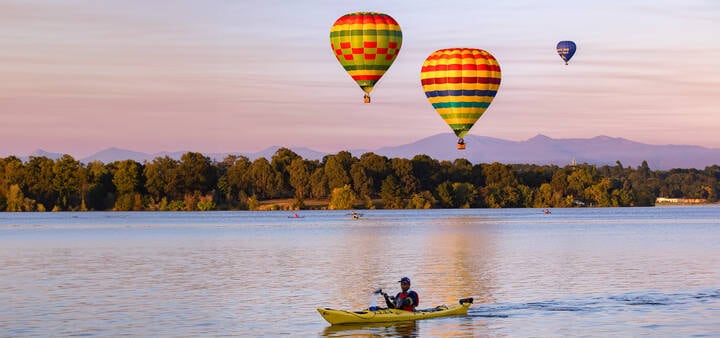 Hot air balloons over kayakers