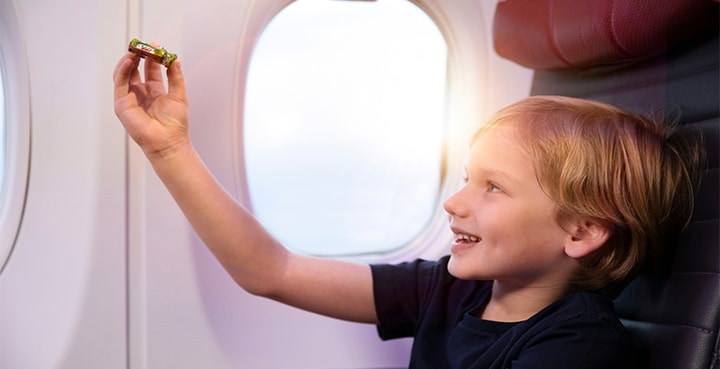 Child passenger holding up toy in cabin on Virgin Australia flight